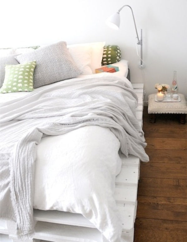 hvite elegante seng-off-paller - en hvit lampe ved siden av den