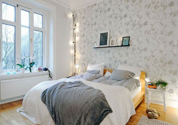 Odanın köşesinde beyaz-yatak odalı-bir-İskandinav-yatak-ilginç-aydınlatma