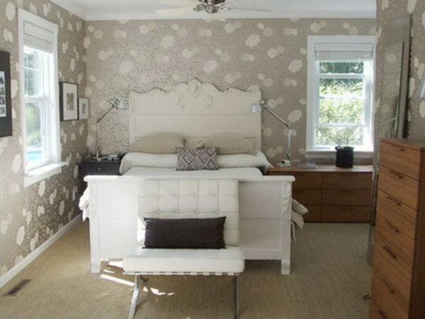 dekorativne figure na steni v spalnici z veliko belo posteljo