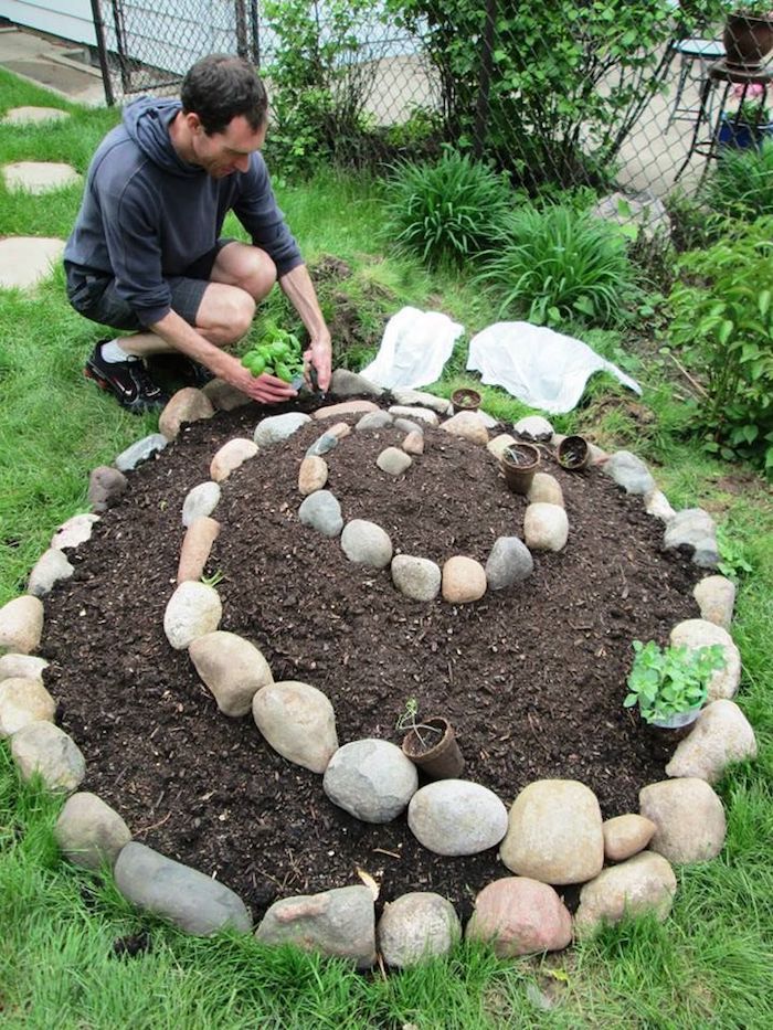 Acum vă arătăm o idee minunată despre designul grădinii, pe care vă puteți bucura cu adevărat - o imagine inspirată cu un bărbat și o mică spirală de plante mini cu plante verzi și pietre mici