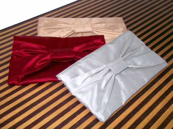 Tre modeller av hemlagade handväskor i olika färger - röd, grå och beige