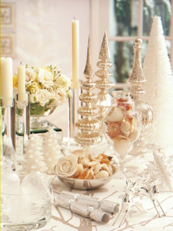 hvite juledekorasjoner - stearinlys ved siden av roser i hvit farge