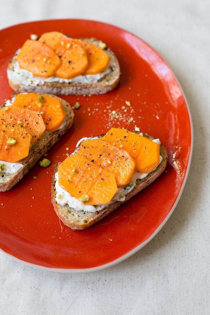 hvordan å spise kaki, stykker brød med persimmonskiver og hvit ost