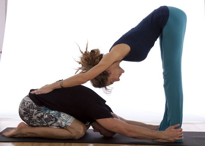 Lita på yoga för älskare, man i bebisposition, kvinna med händer på ryggen, updo för mycket långt hår
