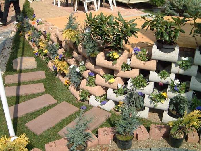 en liten mini hage - ide for hage design - her finner du små steiner med lilla og gule blomster