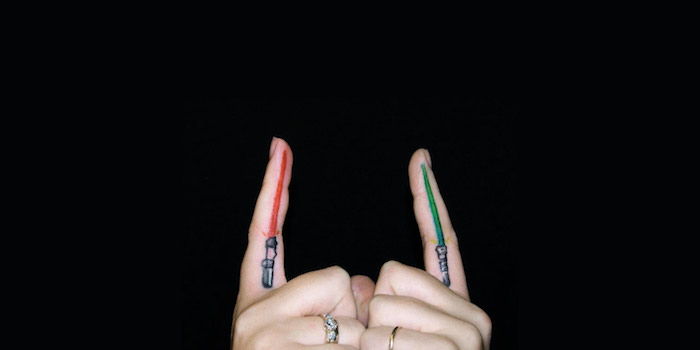 două mâini și două degete, cu un mic luminiș roșu și un tatuaj cu războaie stea, cu o lumină mică