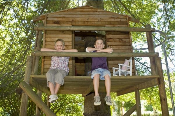 Balkonda oturan iki çocuk ağaç evi